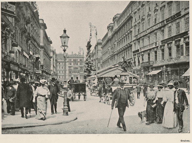 People and carriages (and a dog) traveling down street in Vienna, where Frankl attended school.