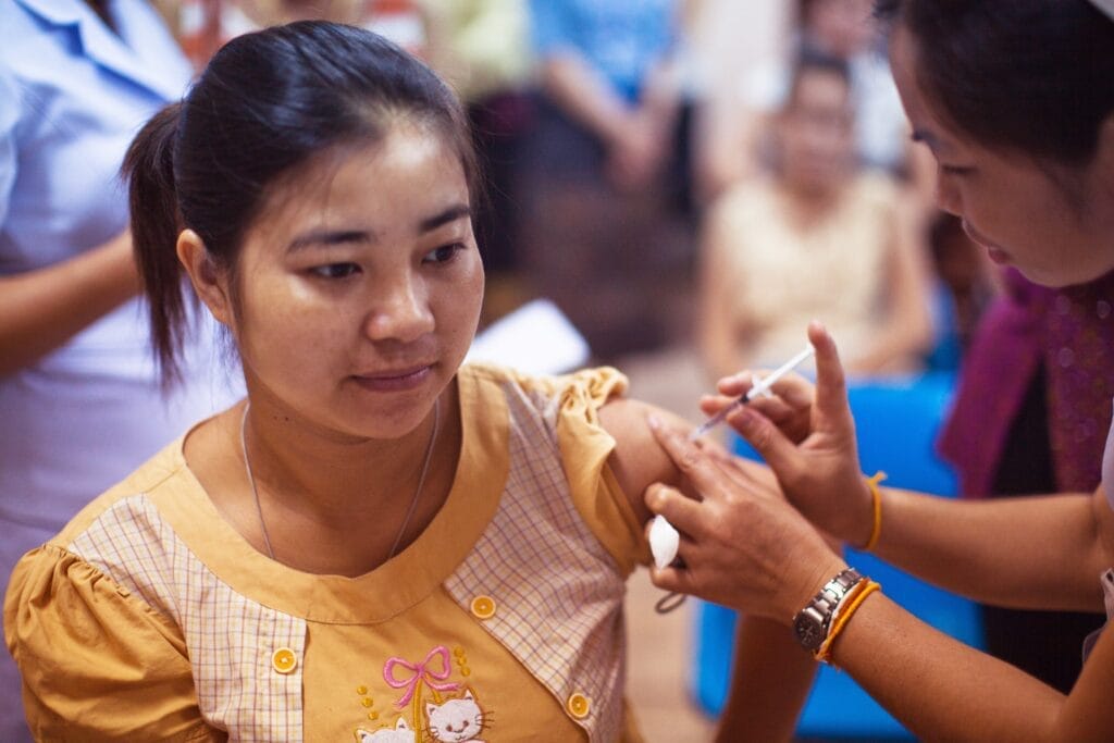Woman looking concerned or unsure while receiving vaccine in her left arm