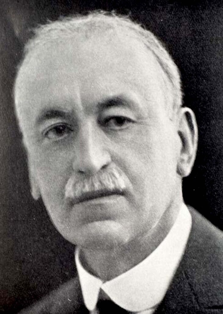 George Murray, a man with a mustache in a tie and jacket