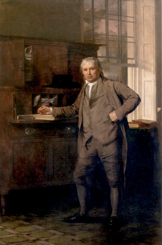 Oil painting of Samuel Coates, a man dressed in a gray vest, suitcoat, and breeches, with a quill on paper and his other hand on his hip in a study, by Thomas Sully.